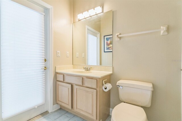 half bath featuring toilet, tile patterned flooring, and vanity