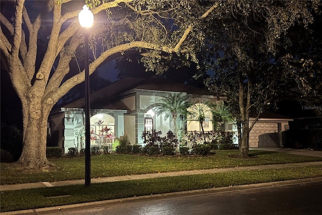 view of front of home featuring driveway, a yard, and a garage