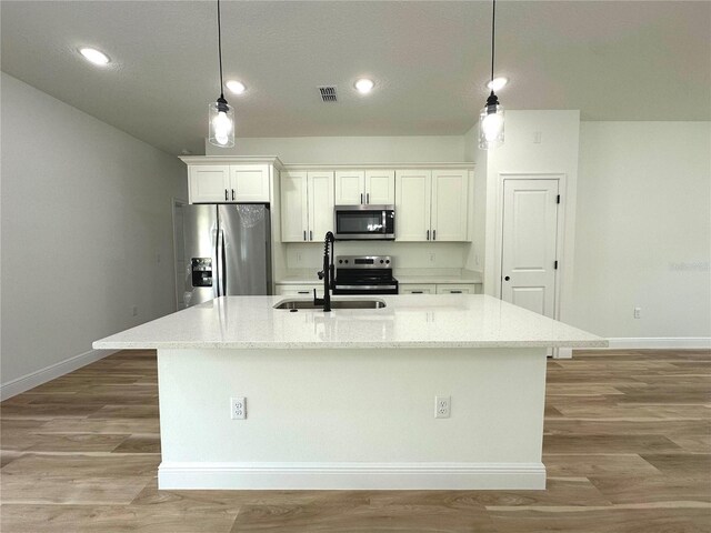 kitchen featuring a sink, stainless steel appliances, white cabinetry, and visible vents