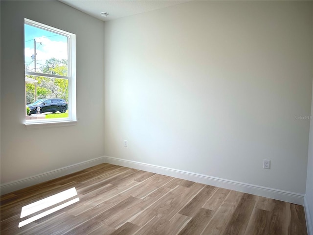empty room featuring baseboards and light wood-type flooring