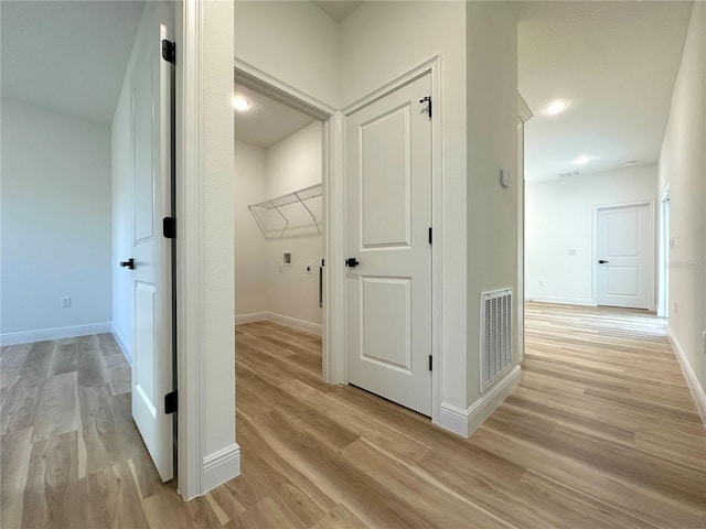 laundry area featuring washer hookup, visible vents, baseboards, and light wood-style floors