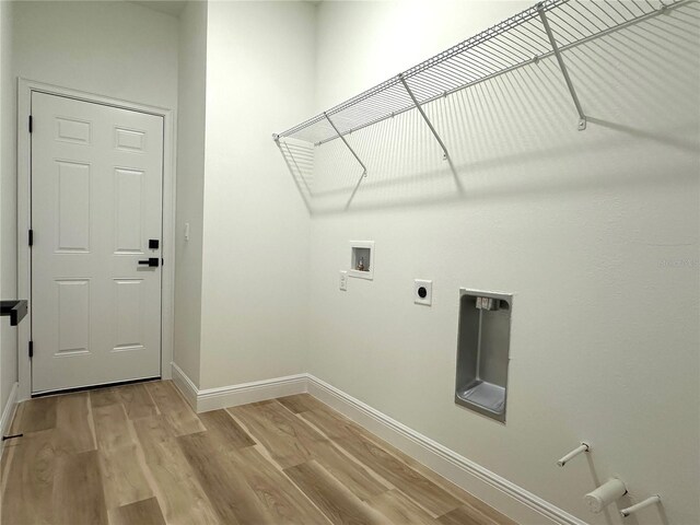 laundry area with laundry area, baseboards, hookup for an electric dryer, light wood-style flooring, and washer hookup