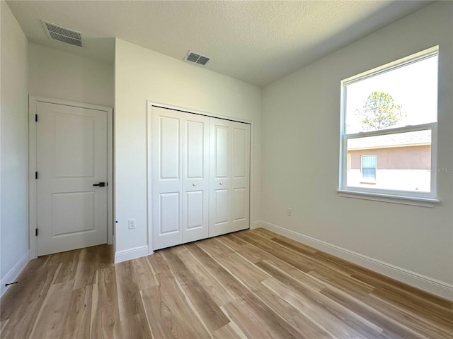 unfurnished bedroom with baseboards, visible vents, and light wood-type flooring