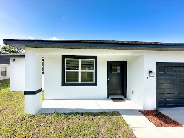 view of front of home featuring a porch, a garage, and stucco siding