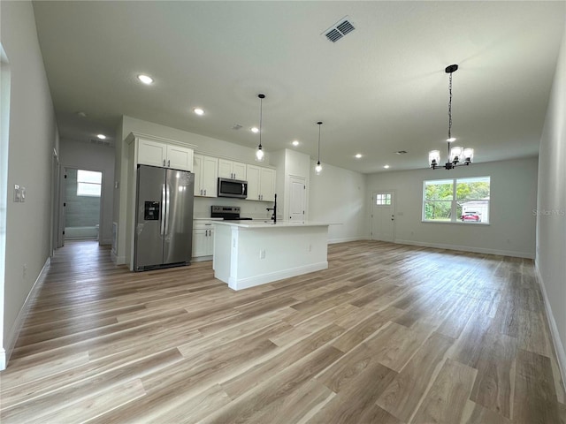 kitchen with an inviting chandelier, stainless steel appliances, open floor plan, recessed lighting, and visible vents