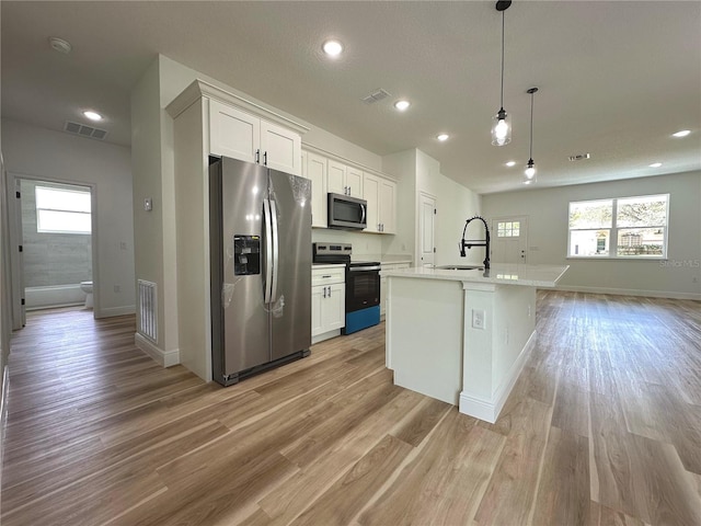 kitchen with white cabinets, appliances with stainless steel finishes, a sink, and visible vents