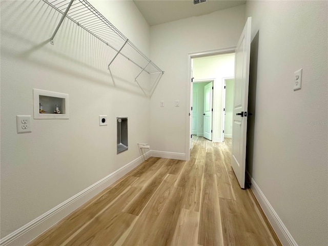 clothes washing area with laundry area, hookup for a washing machine, light wood-style flooring, baseboards, and hookup for an electric dryer