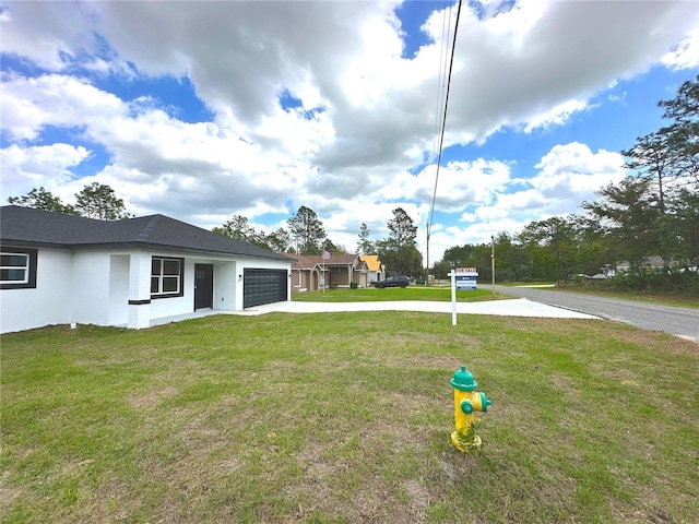 view of yard with a garage and driveway