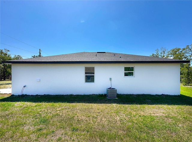 back of property featuring a yard and stucco siding