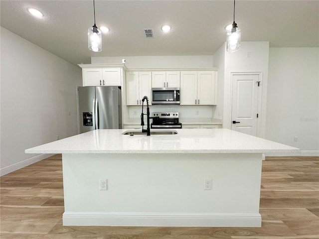 977 W Anderson Ln, Citrus Springs, FL 34434 - kitchen with appliances with stainless steel finishes, a sink, an island with sink, white cabinets, and baseboards