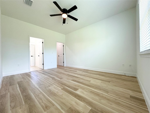 977 W Anderson Ln, Citrus Springs, FL 34434 - unfurnished bedroom with light wood finished floors, baseboards, connected bathroom, and ceiling fan