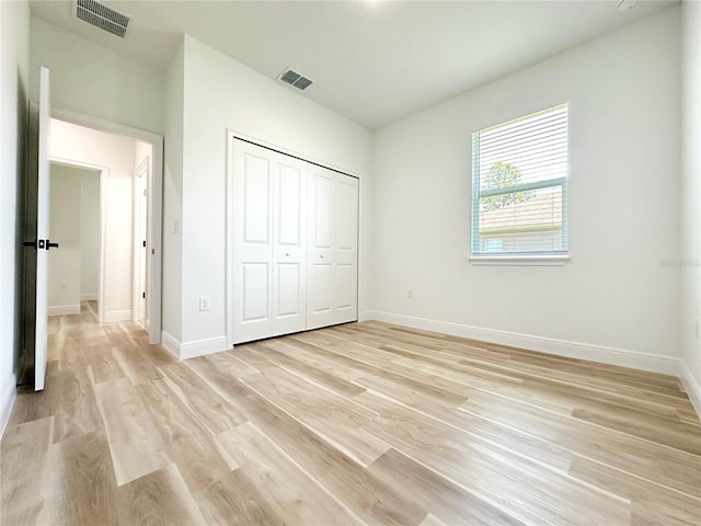 977 W Anderson Ln, Citrus Springs, FL 34434 - unfurnished bedroom with light wood-style floors, baseboards, and a closet