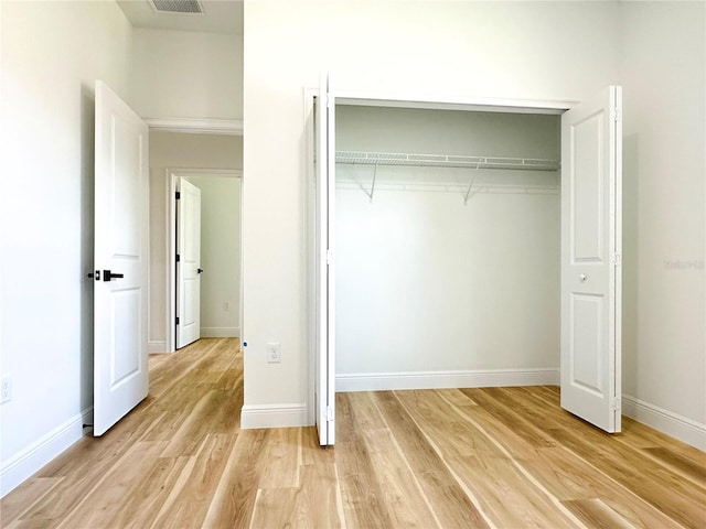 977 W Anderson Ln, Citrus Springs, FL 34434 - unfurnished bedroom with light wood-style flooring, a closet, and baseboards
