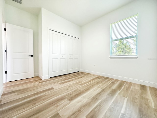 977 W Anderson Ln, Citrus Springs, FL 34434 - unfurnished bedroom featuring light wood-type flooring, baseboards, and a closet