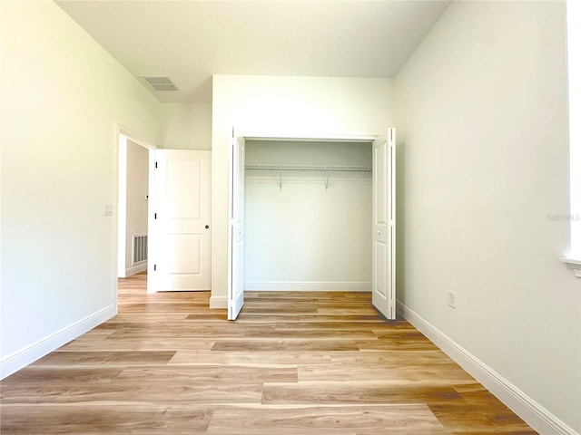 977 W Anderson Ln, Citrus Springs, FL 34434 - unfurnished bedroom with light wood-type flooring, baseboards, and a closet
