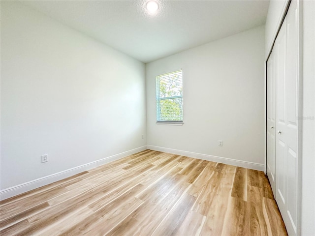 977 W Anderson Ln, Citrus Springs, FL 34434 - unfurnished bedroom featuring a closet, light wood-style flooring, and baseboards