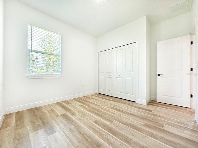 977 W Anderson Ln, Citrus Springs, FL 34434 - unfurnished bedroom featuring light wood-style floors, baseboards, and a closet