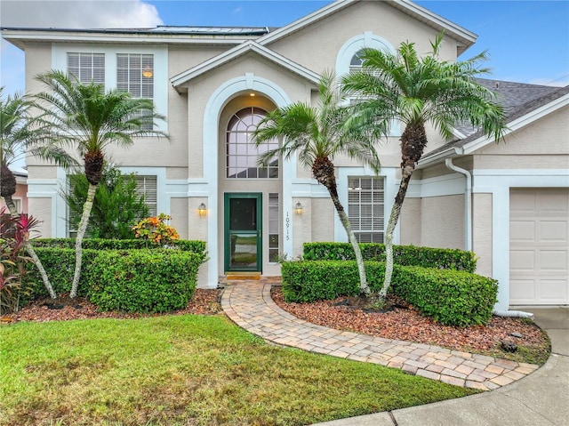 10915 Piping Rock Cir, Orlando, FL 32817 - view of front of property with a shingled roof, stucco siding, an attached garage, and a front lawn