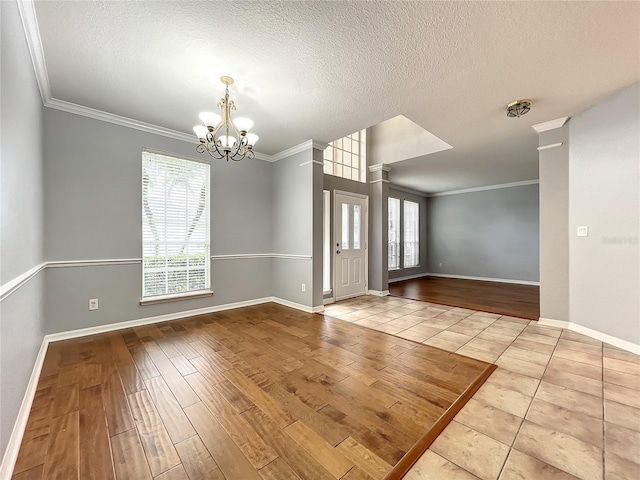 10915 Piping Rock Cir, Orlando, FL 32817 - spare room featuring baseboards, an inviting chandelier, ornamental molding, and wood finished floors