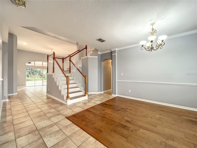 10915 Piping Rock Cir, Orlando, FL 32817 - unfurnished room featuring visible vents, arched walkways, an inviting chandelier, a textured ceiling, and stairway