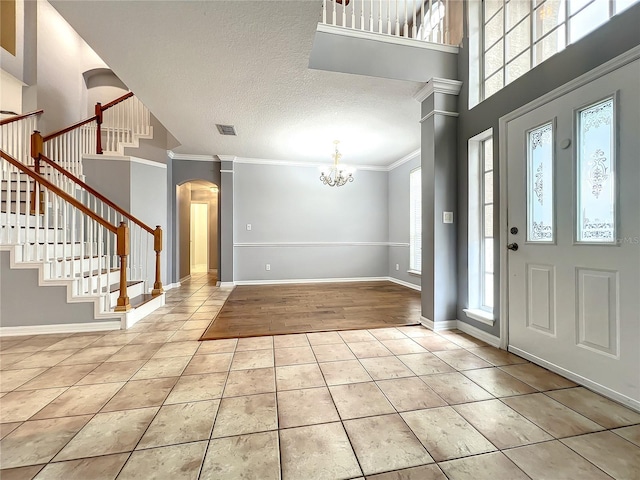 10915 Piping Rock Cir, Orlando, FL 32817 - tiled foyer featuring visible vents, decorative columns, arched walkways, and an inviting chandelier