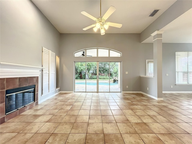 10915 Piping Rock Cir, Orlando, FL 32817 - unfurnished living room featuring visible vents, light tile patterned floors, a tiled fireplace, ceiling fan, and ornate columns