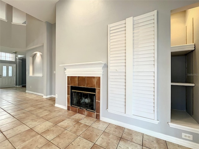 10915 Piping Rock Cir, Orlando, FL 32817 - unfurnished living room featuring a fireplace, a towering ceiling, baseboards, and tile patterned flooring