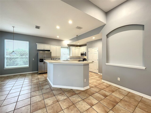 10915 Piping Rock Cir, Orlando, FL 32817 - kitchen with stainless steel appliances, visible vents, white cabinetry, and light countertops