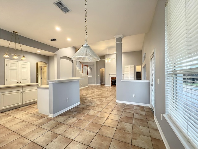 10915 Piping Rock Cir, Orlando, FL 32817 - kitchen with ceiling fan, arched walkways, visible vents, light countertops, and baseboards