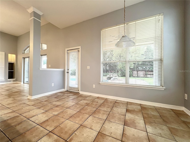 10915 Piping Rock Cir, Orlando, FL 32817 - unfurnished dining area with a high ceiling, a healthy amount of sunlight, light tile patterned floors, and baseboards