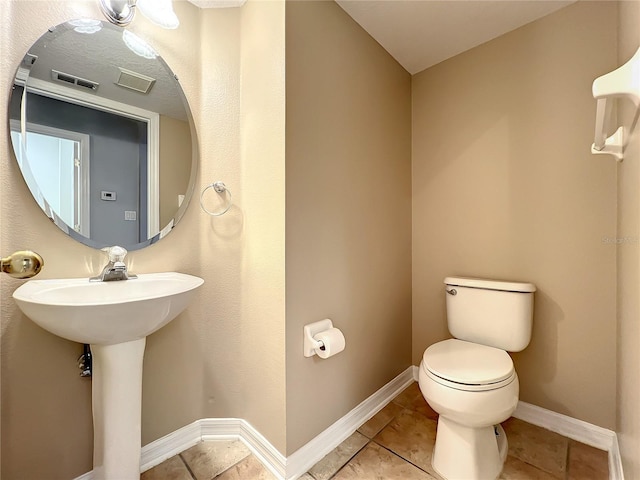 10915 Piping Rock Cir, Orlando, FL 32817 - half bath with toilet, baseboards, tile patterned flooring, and visible vents
