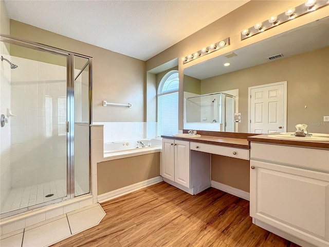 10915 Piping Rock Cir, Orlando, FL 32817 - full bath with vanity, visible vents, a stall shower, and wood finished floors