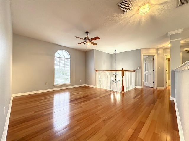 10915 Piping Rock Cir, Orlando, FL 32817 - unfurnished room with visible vents, baseboards, wood finished floors, and ceiling fan with notable chandelier