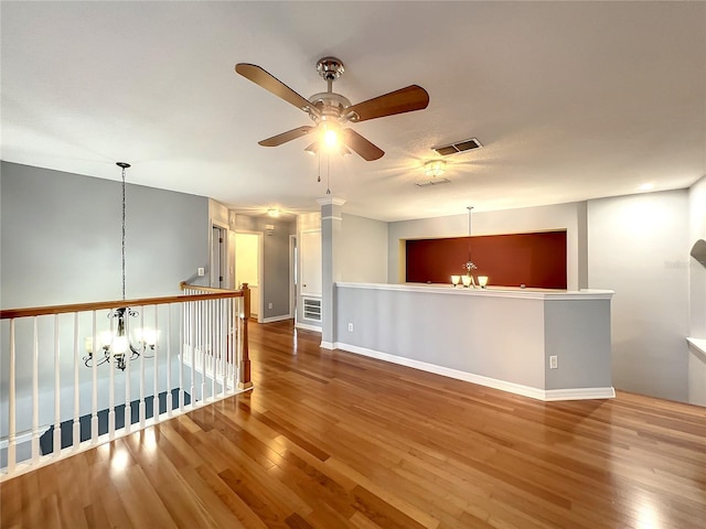 10915 Piping Rock Cir, Orlando, FL 32817 - unfurnished room with wood finished floors, ceiling fan with notable chandelier, baseboards, and visible vents