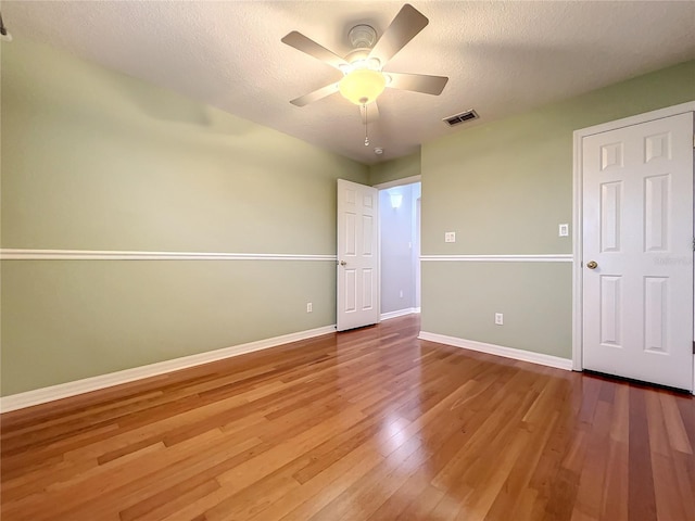 10915 Piping Rock Cir, Orlando, FL 32817 - unfurnished bedroom featuring baseboards, a textured ceiling, visible vents, ceiling fan, and wood finished floors