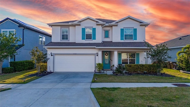 13323 Blossom Valley Dr, Clermont, FL 34711 - traditional home with a front yard, an attached garage, driveway, and stucco siding