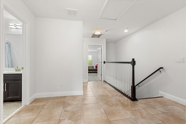 10866 Sunset Ridge Ln, Orlando, FL 32832 - corridor with visible vents, baseboards, light tile patterned floors, a sink, and an upstairs landing