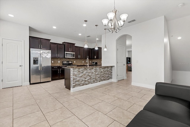10866 Sunset Ridge Ln, Orlando, FL 32832 - kitchen featuring tasteful backsplash, visible vents, arched walkways, open floor plan, and appliances with stainless steel finishes