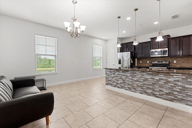 10866 Sunset Ridge Ln, Orlando, FL 32832 - kitchen featuring a notable chandelier, open floor plan, visible vents, decorative backsplash, and stainless steel appliances