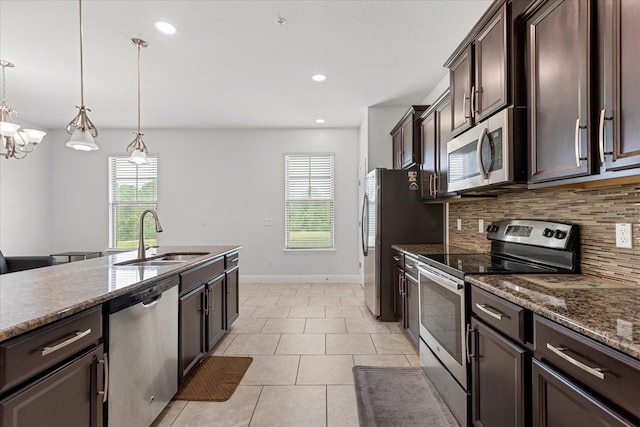 10866 Sunset Ridge Ln, Orlando, FL 32832 - kitchen featuring tasteful backsplash, dark brown cabinetry, light tile patterned floors, stainless steel appliances, and a sink