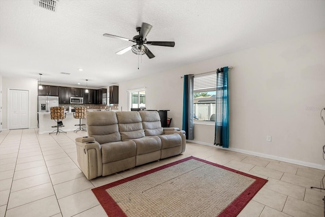 542 Patton Loop, Bartow, FL 33830 - living area featuring ceiling fan, light tile patterned flooring, baseboards, and a textured ceiling