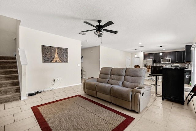 542 Patton Loop, Bartow, FL 33830 - living room with light tile patterned flooring, stairway, ceiling fan, a textured ceiling, and baseboards