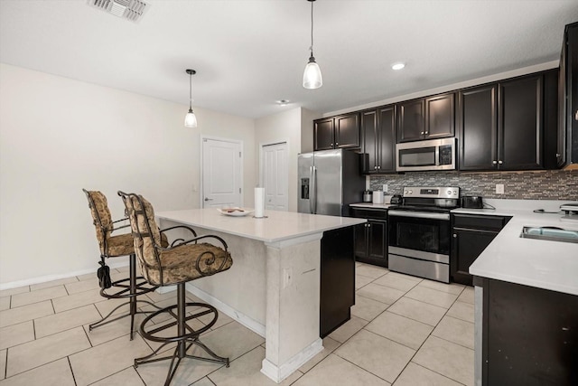 542 Patton Loop, Bartow, FL 33830 - kitchen with appliances with stainless steel finishes, decorative backsplash, a kitchen island, a kitchen breakfast bar, and light countertops