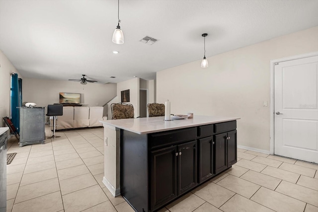 542 Patton Loop, Bartow, FL 33830 - kitchen featuring light tile patterned floors, dark cabinets, ceiling fan, light countertops, and decorative light fixtures
