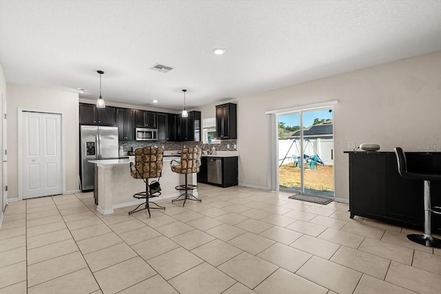 542 Patton Loop, Bartow, FL 33830 - kitchen with stainless steel appliances, tasteful backsplash, a breakfast bar area, a center island, and dark cabinets