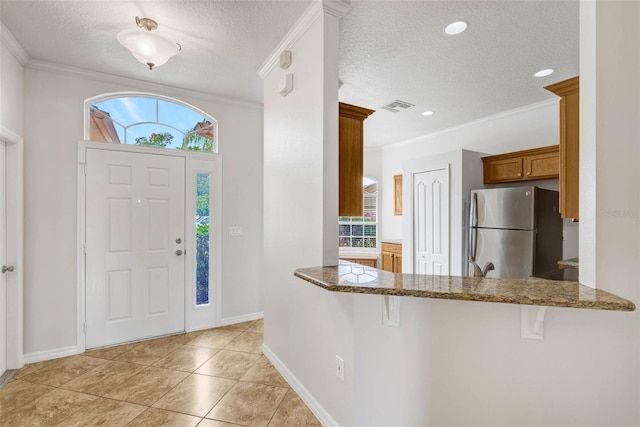 7762 Newlan Dr, Orlando, FL 32818 - foyer entrance with ornamental molding, visible vents, plenty of natural light, and a textured ceiling