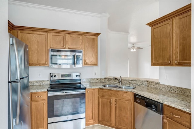 7762 Newlan Dr, Orlando, FL 32818 - kitchen with crown molding, appliances with stainless steel finishes, a sink, and light stone countertops