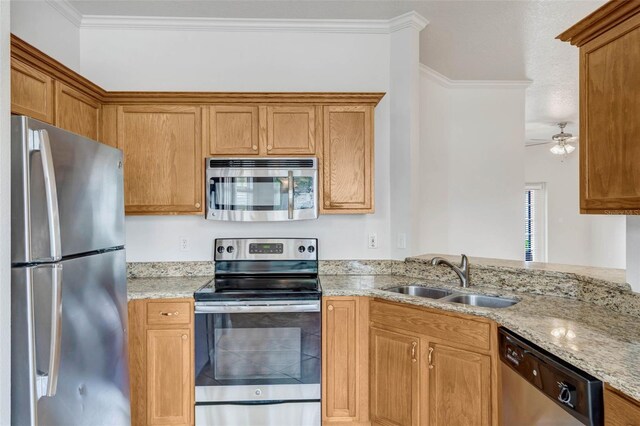 7762 Newlan Dr, Orlando, FL 32818 - kitchen featuring light stone countertops, ornamental molding, a sink, stainless steel appliances, and brown cabinets