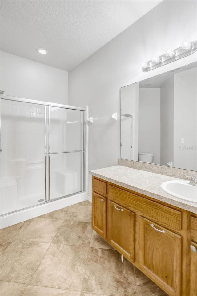 7762 Newlan Dr, Orlando, FL 32818 - bathroom with vanity, a stall shower, and a textured ceiling