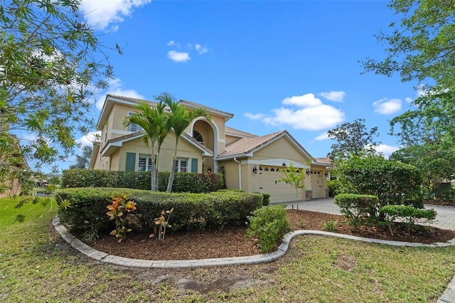 3583 Valleyview Dr, Kissimmee, FL 34746 - mediterranean / spanish-style house featuring driveway, an attached garage, and stucco siding